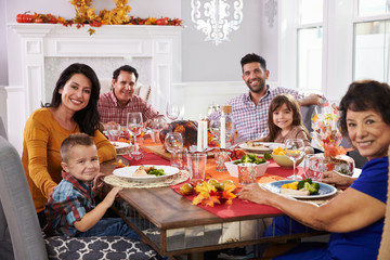 Family With Grandparents Enjoying Thanksgiving Meal At Table