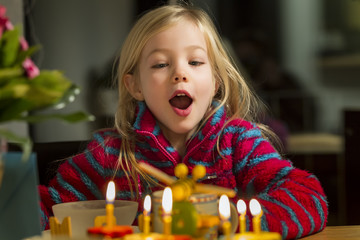 Fototapeta fröhliches Kind bläst Kerzen aus obraz