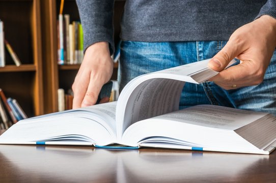 The man opening and browsing the book pages