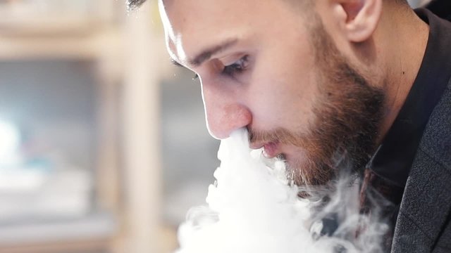 Man Exhaling smoke from a vaporizer shot in slow motion