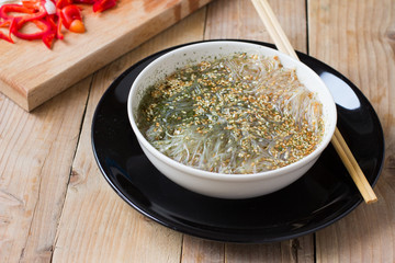 Cooked Cellophane noodles in a bowl with traditional chinese wooden chopsticks