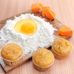 Cupcakes, flour and egg on kitchen table