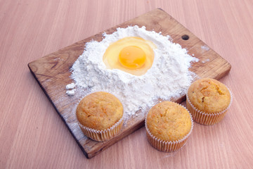 Cupcakes, flour and egg on kitchen table