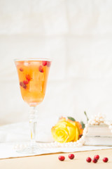 Glass of cranberry cocktail with vintage books and pearls