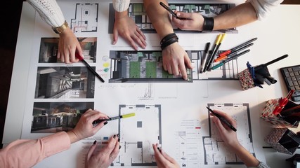 Top view of architects hands drawing of modern house with material sample