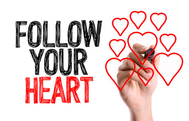 Hand with marker writing: Follow Your Heart