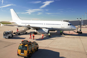 Abfertigung eines Flugzeuges am Flughafengebäude - Verladung von Gepäck und Check durch...