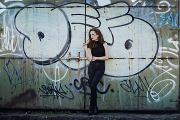 femme fumant devant mur de graffitis