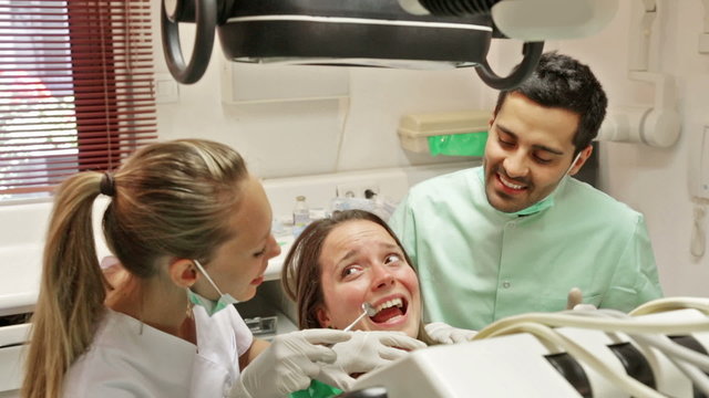Portrait of doctor and frightened patient at dental clinic