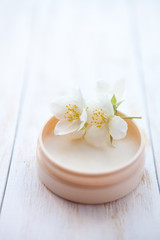 Fototapeta na wymiar cream with jasmine blossom on white wooden table