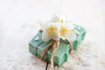 Obraz na płótnie Canvas Spa setting with jasmine blossom, natural handmade soap and sea salt