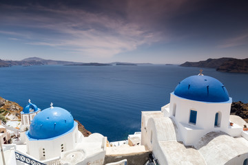 Fototapeta na wymiar Blue domed churches on the Caldera at Oia on the Greek Island of