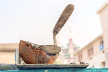 Cement gray mix and spatula/Cement gray mix and spatula tool on the wall.