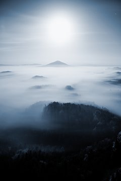 Full moon night. Fairy misty night  in mountain of Bohemian-Saxony Switzerland. Hills like islands  increased from heavy  fog.