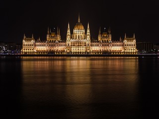 Fototapeta premium The parliament of Budapest reflecting in the Danube river at nig