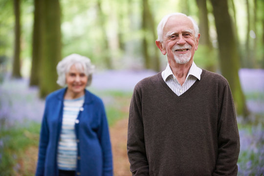 Senior Couple Walking Through Bluebells Woods