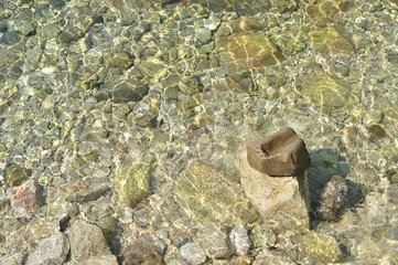 At the bottom of the sea. View through water.  Big stone on the right bottom of frame