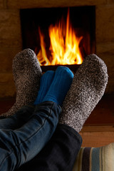 Father And Child Warming Feet By Fire