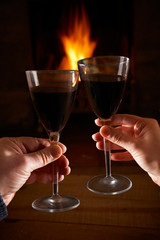 Couple With Glass Of Wine Relaxing By Fire