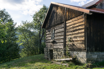 Wooden cottage on green hill in sunny autumn afternoon - Nobody