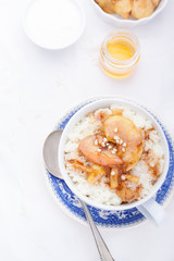 Rice pudding with caramelized apples and honey in a white ceramic cup