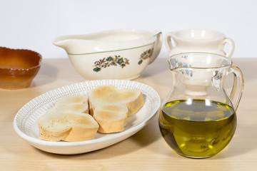 Crystal cruet containing Extra Virgin olive oil beside a dish with several toasts. Mediterranean breakfast