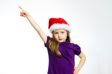 Cute little girl in santa red hat showing by hand
