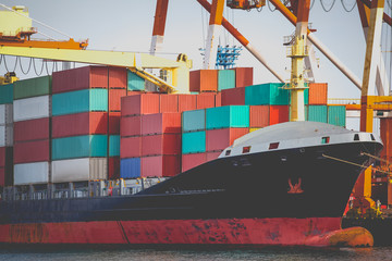 Naklejka premium Cargo freight ship with stacked container at harbor terminal..