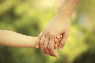 Father and daughter hands outdoors