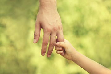 Father and daughter hands outdoors