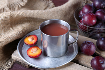 Delicious plum juice with fruits on table close up
