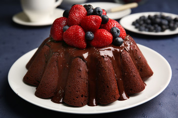 Delicious chocolate cake with strawberries in plate on table, closeup