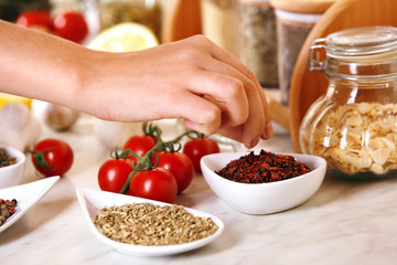 Variety of spices in ceramic containers on the kitchen table