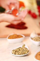 Variety of spices in ceramic containers on the kitchen table