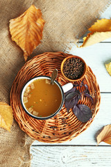 Mug of soup on wicker mat on a table