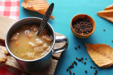 Mug of soup on wooden mat