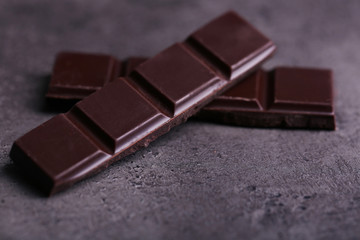 Dark chocolate pieces on  dark gray background