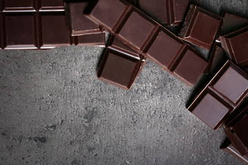 Dark chocolate pieces and coffee grains on dark gray background