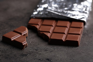 Chocolate bar in foil  on gray background