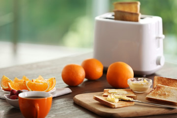 Served table for breakfast with toast, coffee and fruit, on blurred background