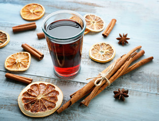Tasty mulled wine and spices, on blue wooden background, close-up