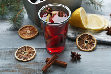 Tasty mulled wine and spices, on blue wooden background, close-up