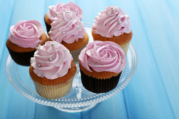 Tasty cupcakes on color wooden background