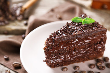 Chocolate cake with chocolate cream and fresh berries on plate, on wooden background