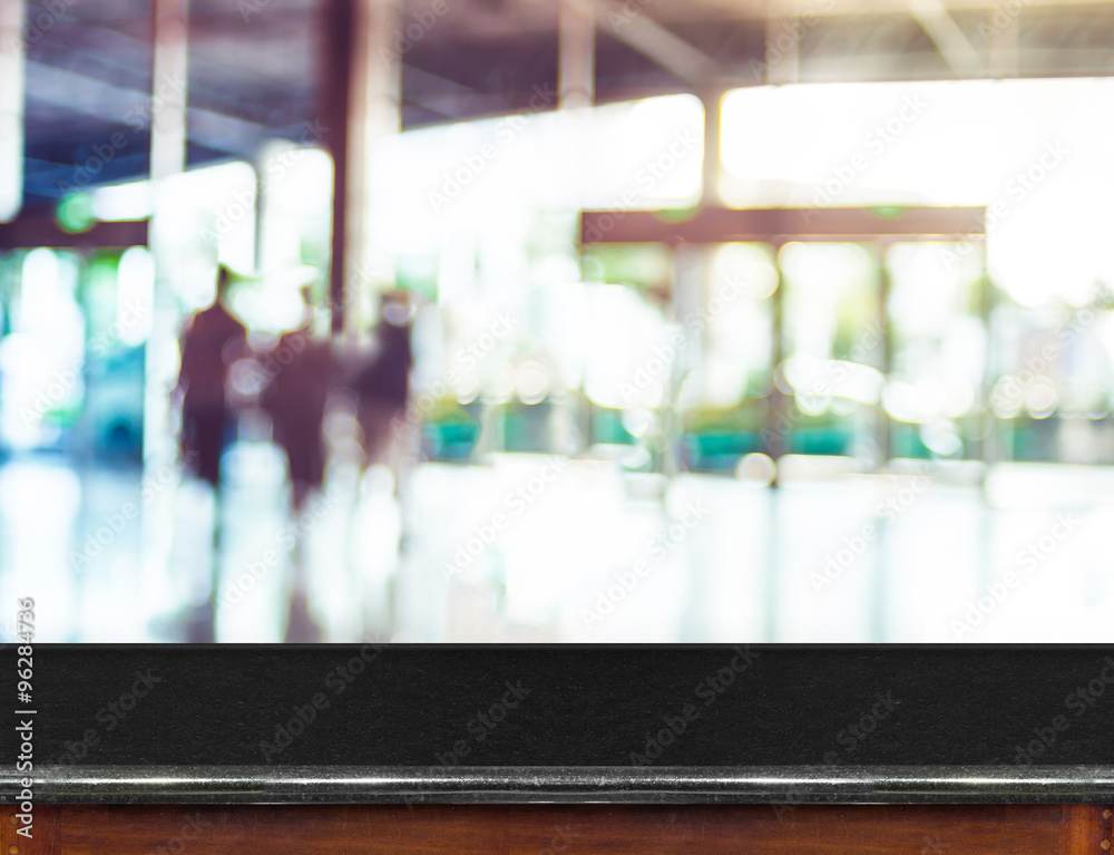 Poster empty black marble table top and blurred people in building corr