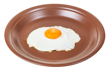 fried egg on brown plate isolated on white