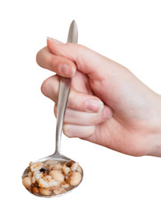 female hand holds tablespoon with beans soup