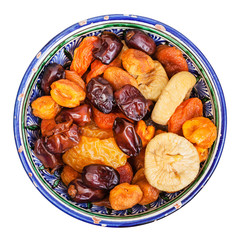 top view of dried fruits in ceramic bowl isolated