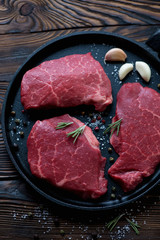Frying pan with raw fresh marbled meat steaks, closeup, top view