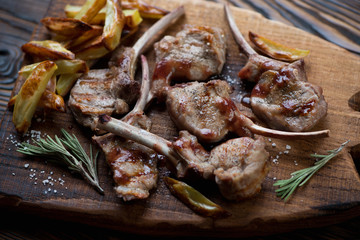 Grilled bobby veal rack steaks with potatoes and sauce, close-up